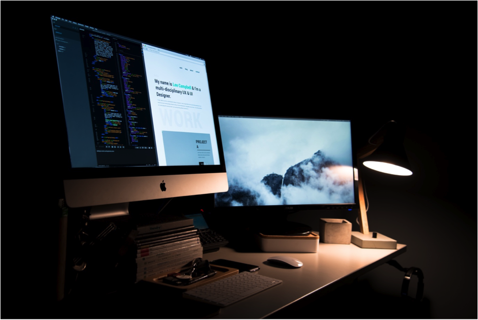 A website open on a desktop monitor in a dimly lit workspace